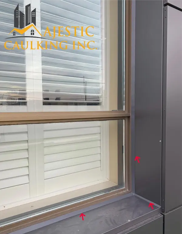 Worker caulking a window