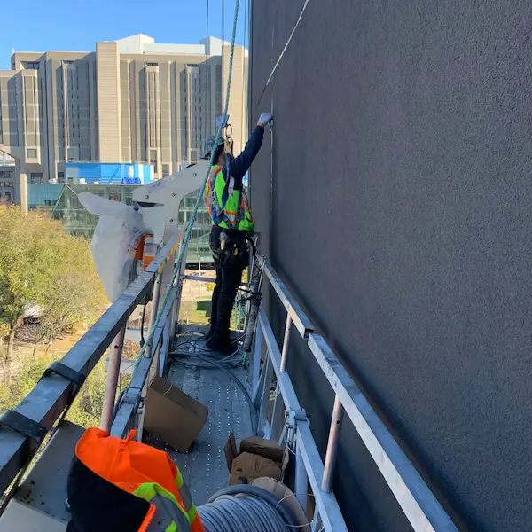 Worker caulking a window