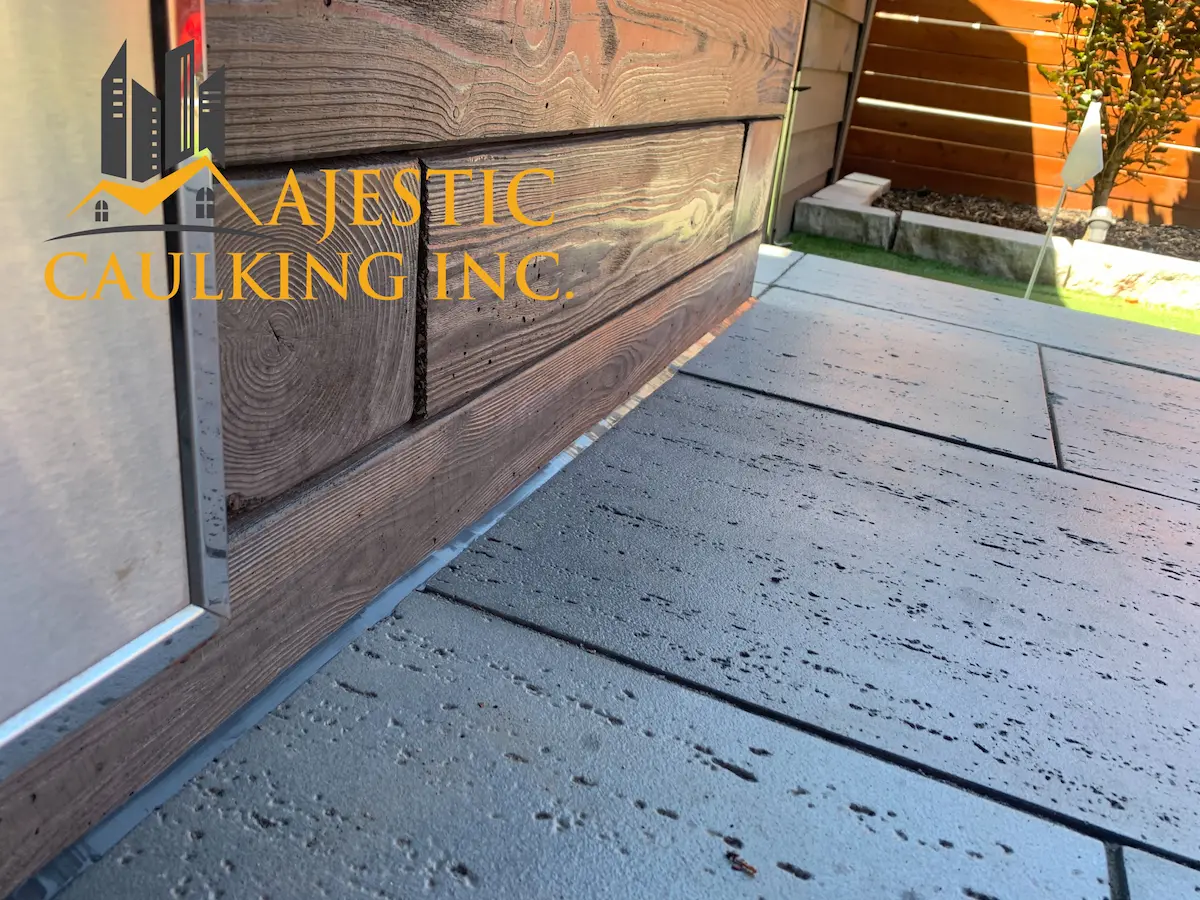 Worker caulking a window