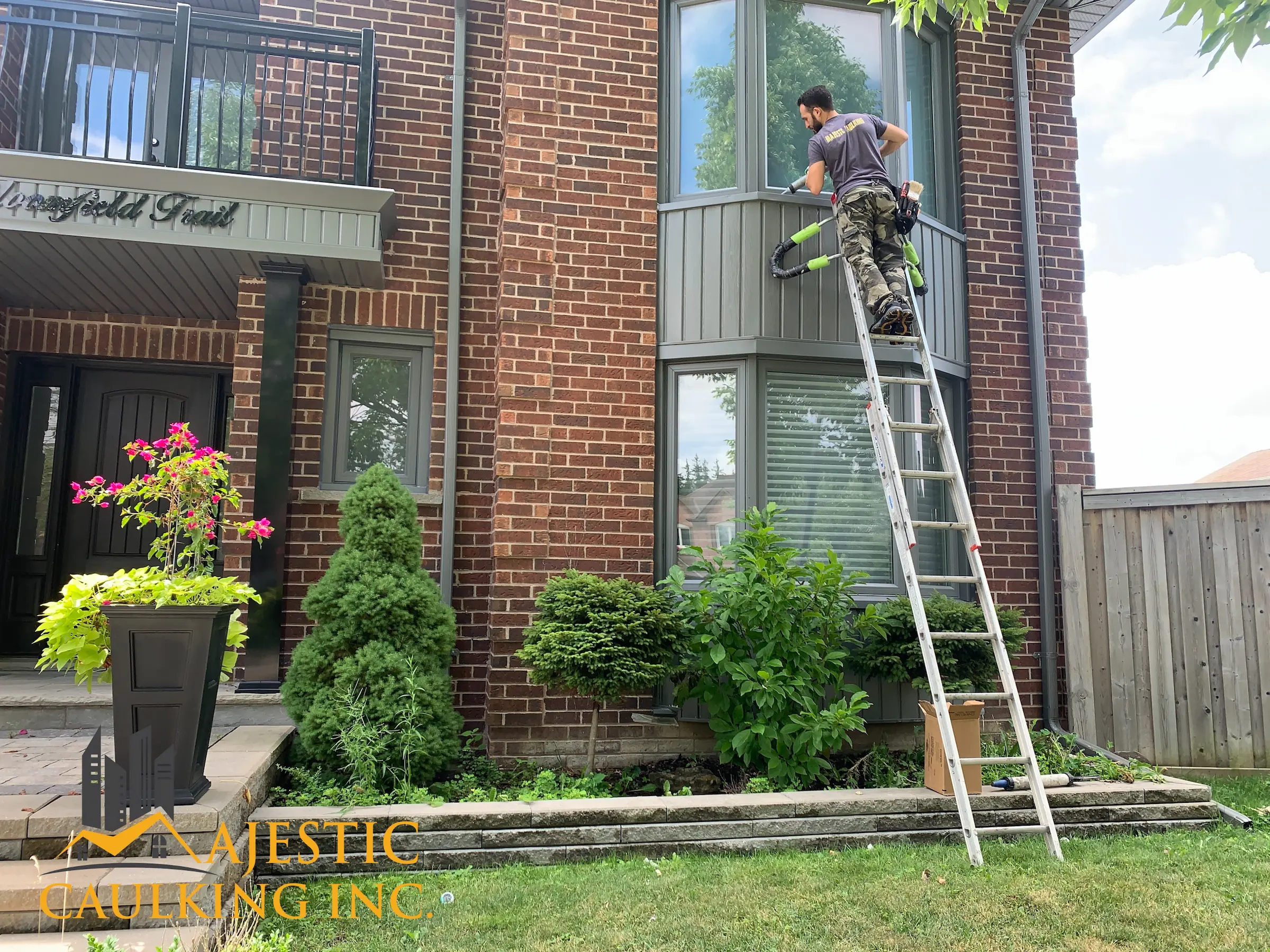 Worker caulking a window