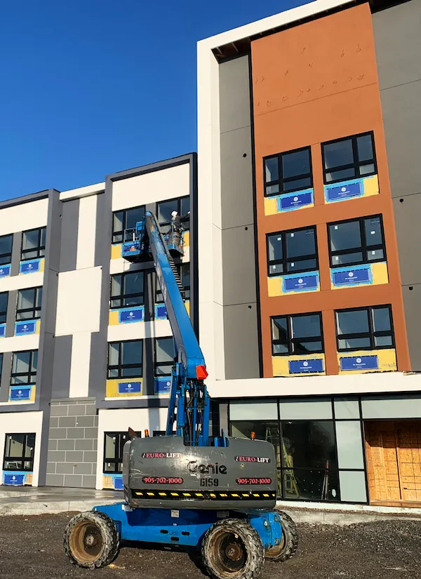Worker caulking a window